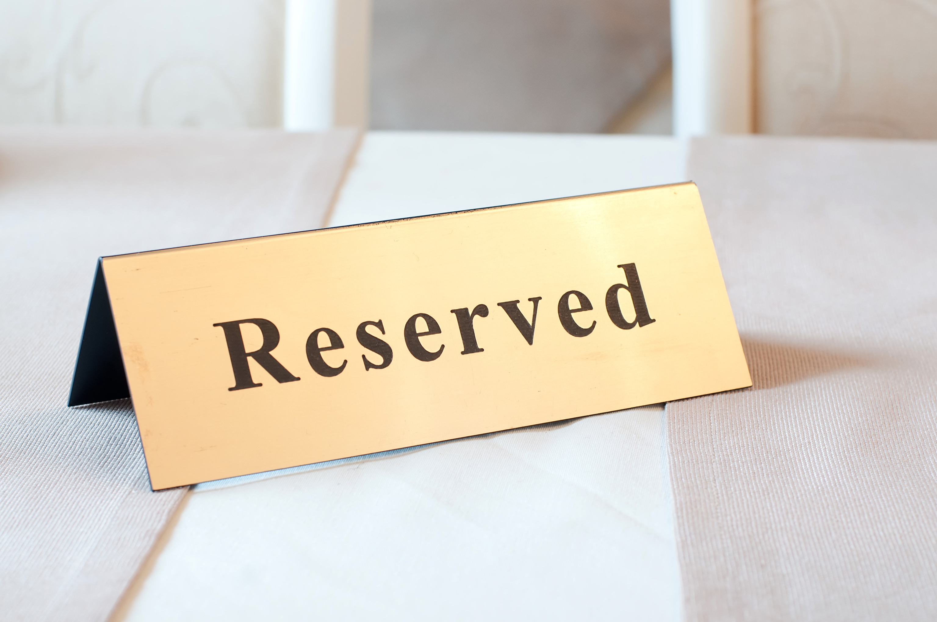 Reserved sign, reservation. On the table. Gold